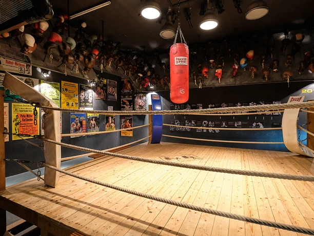 German Sports & Olympic Museum - Exhibition Hall Boxing ring with a punching bag, boxing gloves, and historical posters at the Cologne Sports Museum