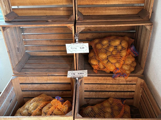 Gestapelte Holzkisten mit Kartoffelsäcken.