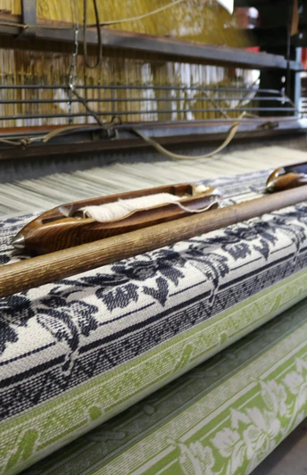 Tuchmacher Museum Bramsche Webstuhl mit floralen Mustern in Blau und Grün, Textilherstellung im traditionellen Stil.