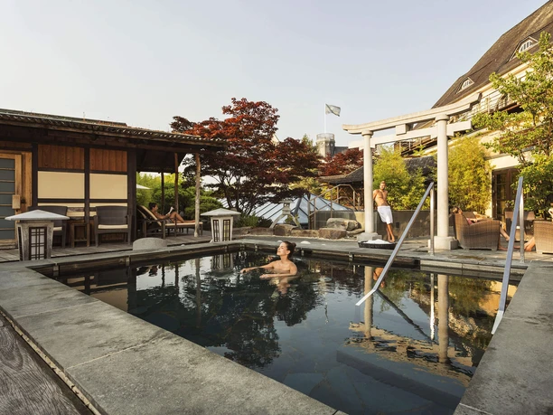 Zen-Garten im Neptunbad Köln mit Pool, Pavillon, Sitzbereich und entspannten Gästen
