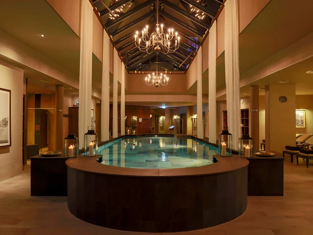 Claudius Therme - Indoor Area Evening atmosphere at the Claudius Therme spa, featuring a pool, candles, and chandeliers
