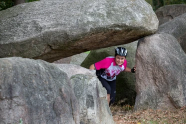 Een van de meer dan 70 megalithische graven langs de fietsroute van de megalietcultuur Een fietser bij een van de megalithische graven in het Osnabrücker Land op de fietsroute van de megalietcultuur