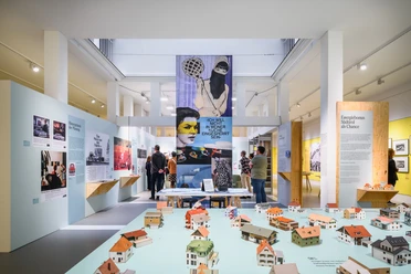 Visitors in exhibition hall with model houses