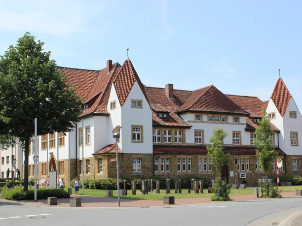 Radeln auf der Hügeltour Historisch gebouw met opvallende torens, rode pannendaken en goed onderhouden paden.