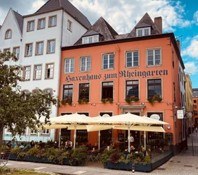 Haxenhaus zum Rheingarten mit Terrasse, Sonnenschirmen und Gästen in Köln