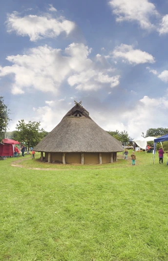 Radeln auf dem OC 3 - Rund um Venne - Mühle, Moor und Varusschlacht Rundes Reetdachhaus umgeben von grüner Wiese, Bäumen und bunten Zelten an einem sonnigen Tag.Round thatched roof house surrounded by green meadows, trees and colorful tents on a sunny day.Rundt hus med stråtag omgivet af grønne enge, træer og farverige telte på en solskinsdag.Rond huis met rieten dak omringd door groene weiden, bomen en kleurrijke tenten op een zonnige dag.