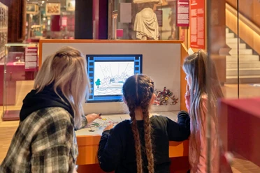Kinder an interaktiver Medienstation im Museum