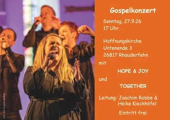 Gospelchor auf der Bühne, rechts orangefarbene Infotafel zum Konzert in Rhauderfehn.