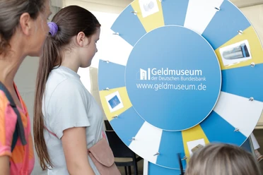 Besucher vor Glücksrad im Geldmuseum der Bundesbank