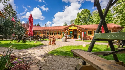 Biggis Jodlerstübchen mit Biergarten, Holzbänken und roten Sonnenschirmen in Wernigerode.