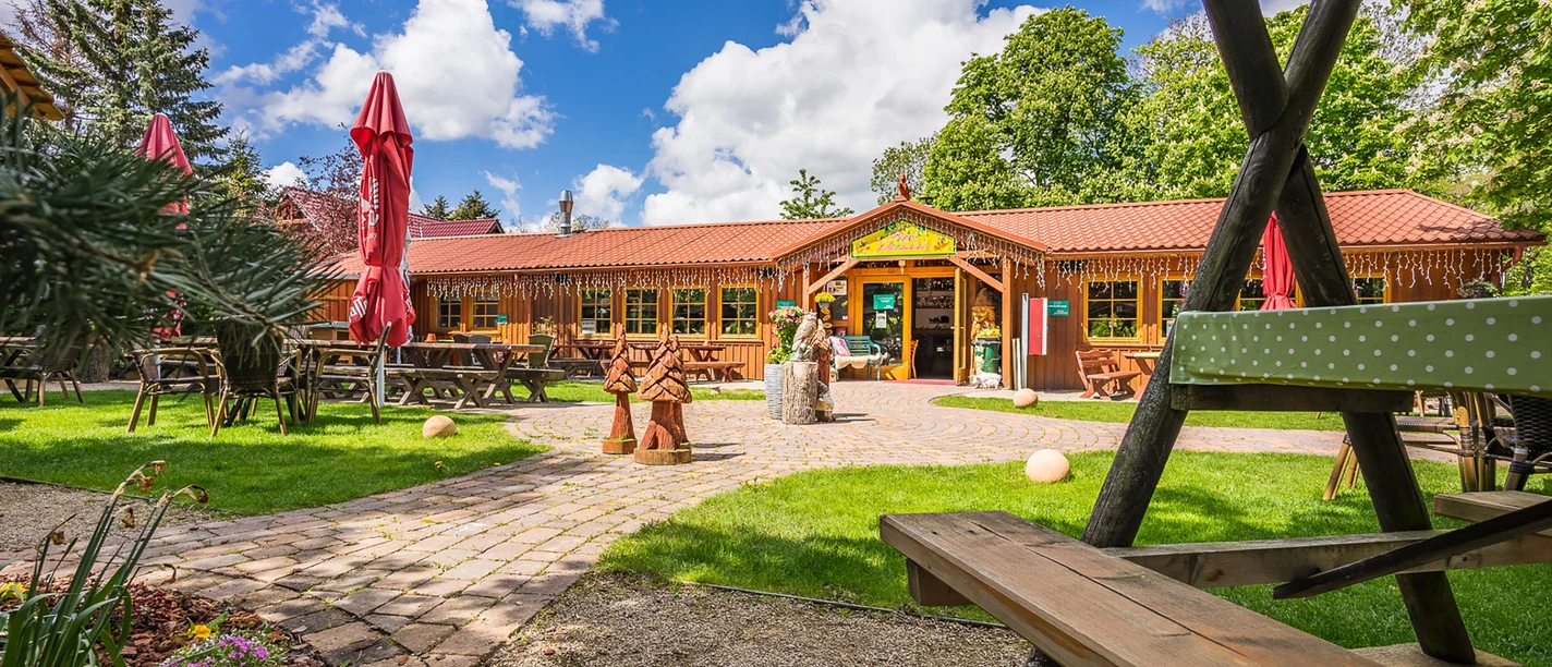 Biggis Jodlerstübchen mit Biergarten, Holzbänken und roten Sonnenschirmen in Wernigerode.
