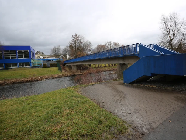 Blaue Fußgängerbrücke vomn Parkplatz in der Arnsberger Straße zum Freibad Meschede über die Ruhr bei bedecktem Himmel