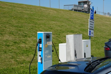 Eine E-Ladesäule vor einem Deich