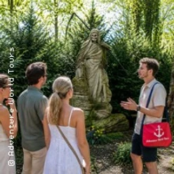 Friedhofsführung am Melaten: drei Gäste betrachten mit Guide eine historische Statue