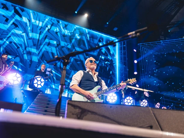 Die 80er live Gitarrist auf Konzertbühne mit blauem Licht bei Die 80er live in Köln