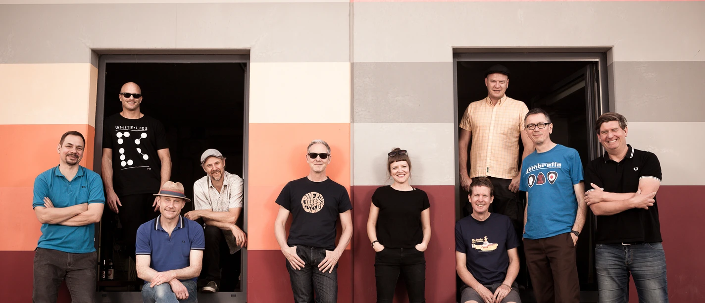 Musikgruppe vor Gebäude mit zwei Türen
