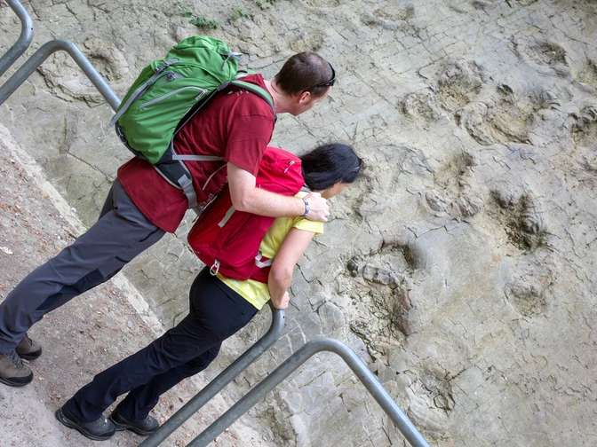 Dinosaurussporen in Bad Essen De Wittekindsweg brengt wandelaars onder meer naar de dinosaurussporen in Bad Essen-BarkhausenPersonen betrachten Spuren prähistorischer Dinosaurier in einer Felswand.People look at traces of prehistoric dinosaurs in a rock face.Folk kigger på spor af forhistoriske dinosaurer i en klippevæg.