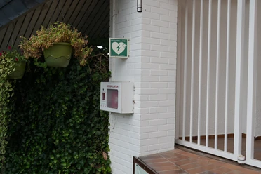 Defibrillator an einem Gebäude befestigt
