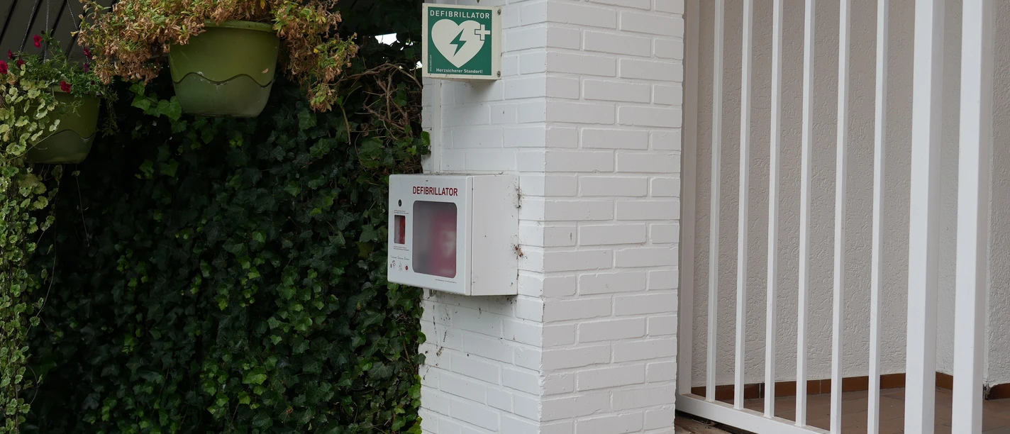 Defibrillator an einem Gebäude befestigt