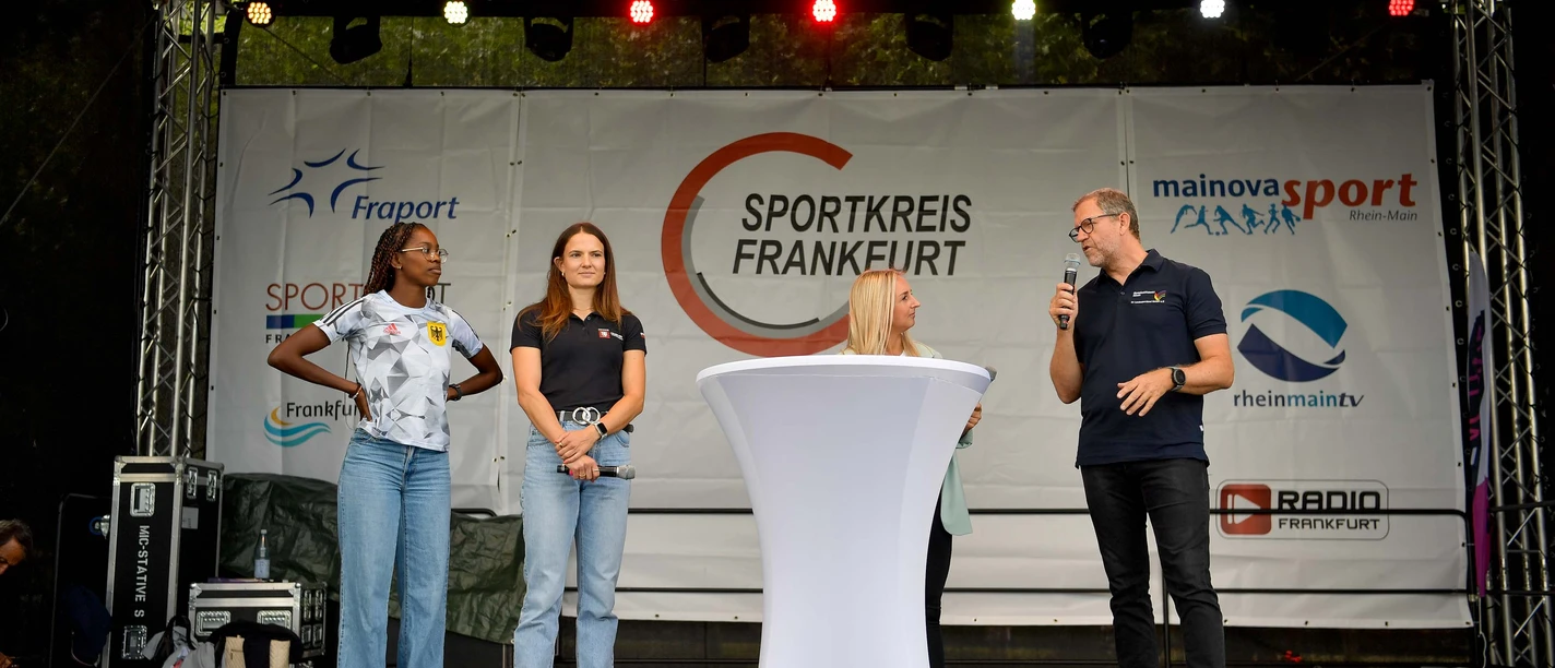 Female athletes and a host on stage at the Frankfurt Sports Association.