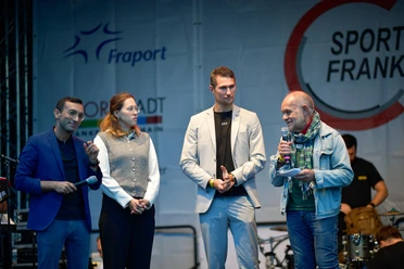 Podiumsgespräch auf der Bühne mit Gästen und Moderator vor Sportkreis-Banner.