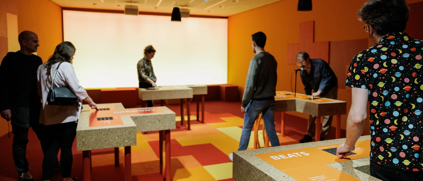 Besucher an interaktiven Stationen in Ausstellungshalle