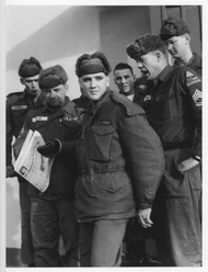 US-Soldaten in Uniform mit Zeitung vor Gebäude