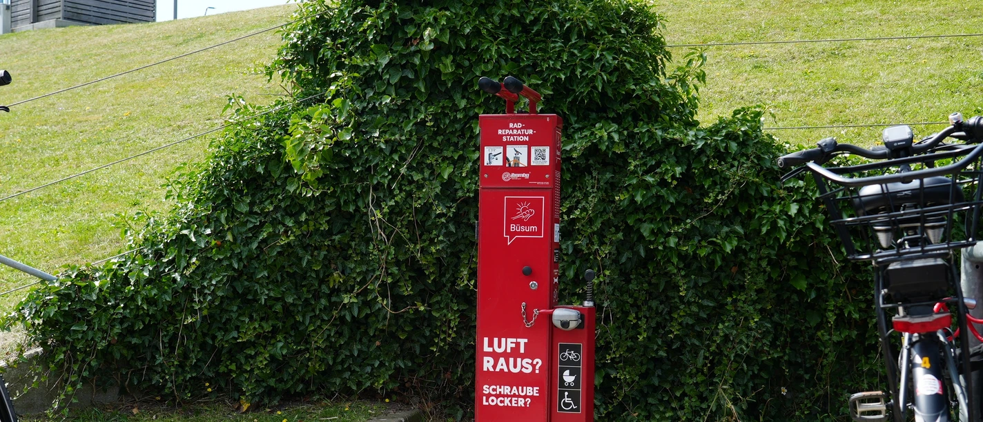 Eine Fahrradreparaturstation vor einem Deich