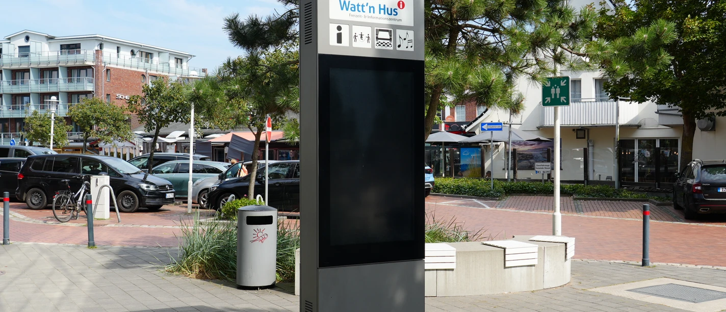 Eine Infotafel vor einem Parkplatz