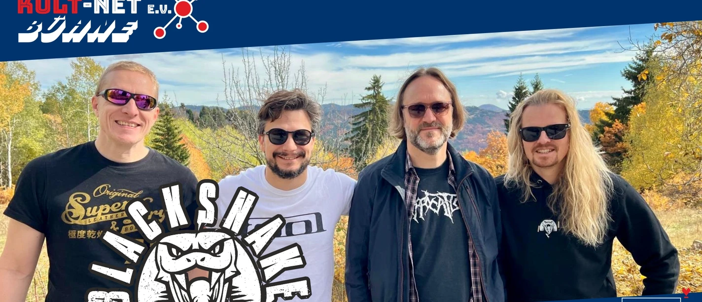 Vier rockig aussehende Bandmitglieder lächeln draußen für ein Foto
