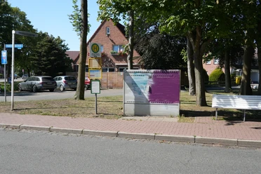 Eine Haltestelle vor ein paar Bäumen