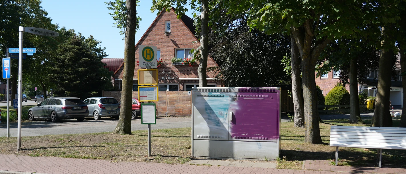 Eine Haltestelle vor ein paar Bäumen