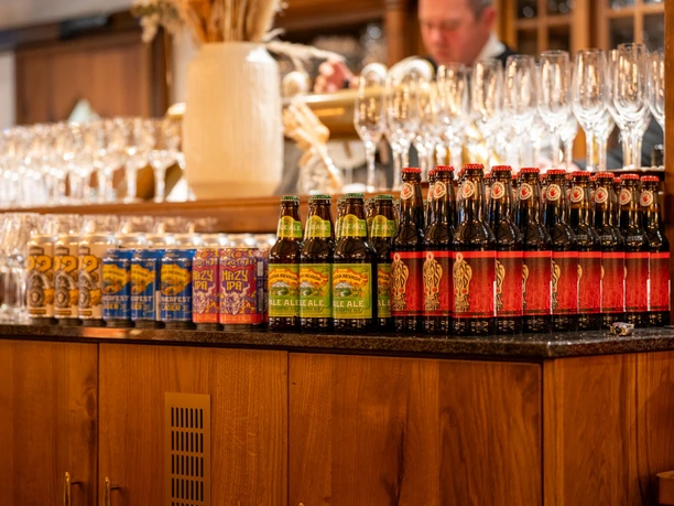 Bierflaschen und Gläser auf einer Holztheke im Gutshof Itterbach