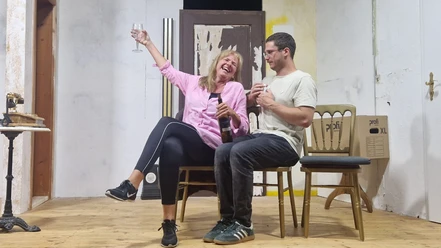 Theaterszene mit zwei Personen und Sektglas