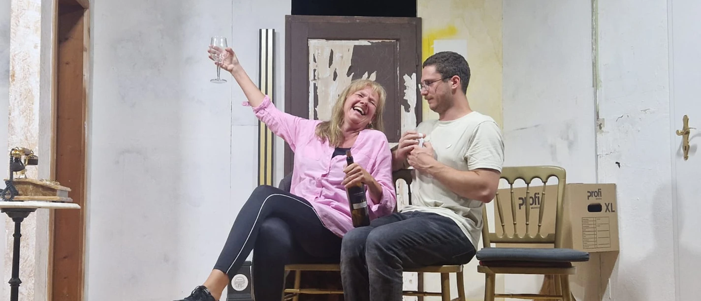 Theaterszene mit zwei Personen und Sektglas