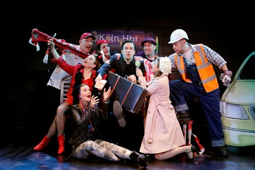 The Himmel und Kölle ensemble in colorful costumes on stage at the Volksbühne Köln