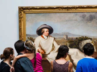 People are looking at a large painting in an art gallery.