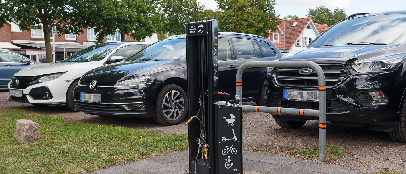 Eine Fahrradreparaturstation vor einem Parkplatz