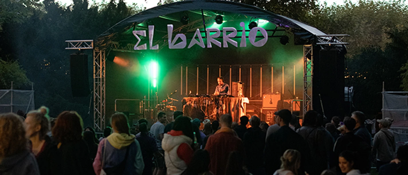 Abendliches Konzert "El Barrio" mit DJ und Zuschauergruppe.
