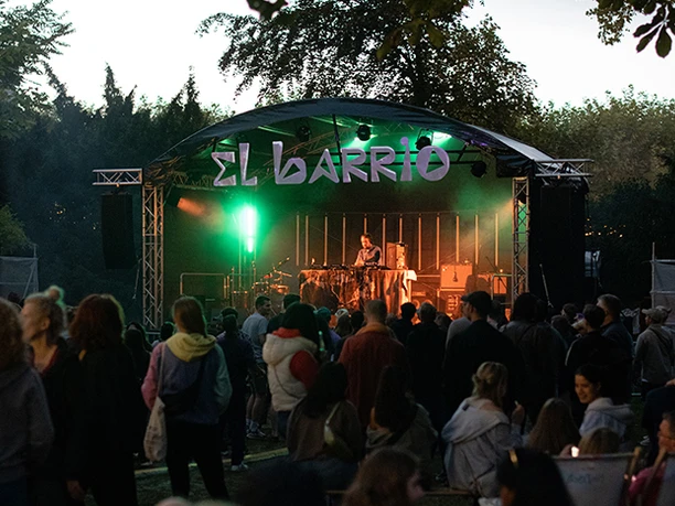 Abendliches Konzert "El Barrio" mit DJ und Zuschauergruppe.