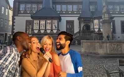 Vier singende Menschen mit Mikrofon vor dem historischen Rathaus auf dem Einbecker Marktplatz.