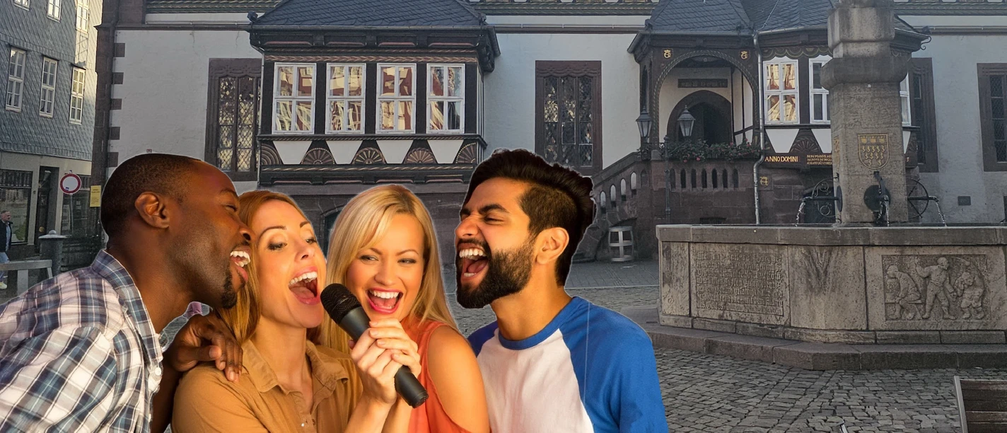 Vier singende Menschen mit Mikrofon vor dem historischen Rathaus auf dem Einbecker Marktplatz.