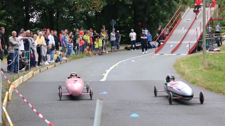 Zwei Seifenkisten rasen beim Overather Cup vor Publikum die Strecke hinab