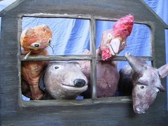 Vier tierische Handpuppen schauen durch ein Fenster