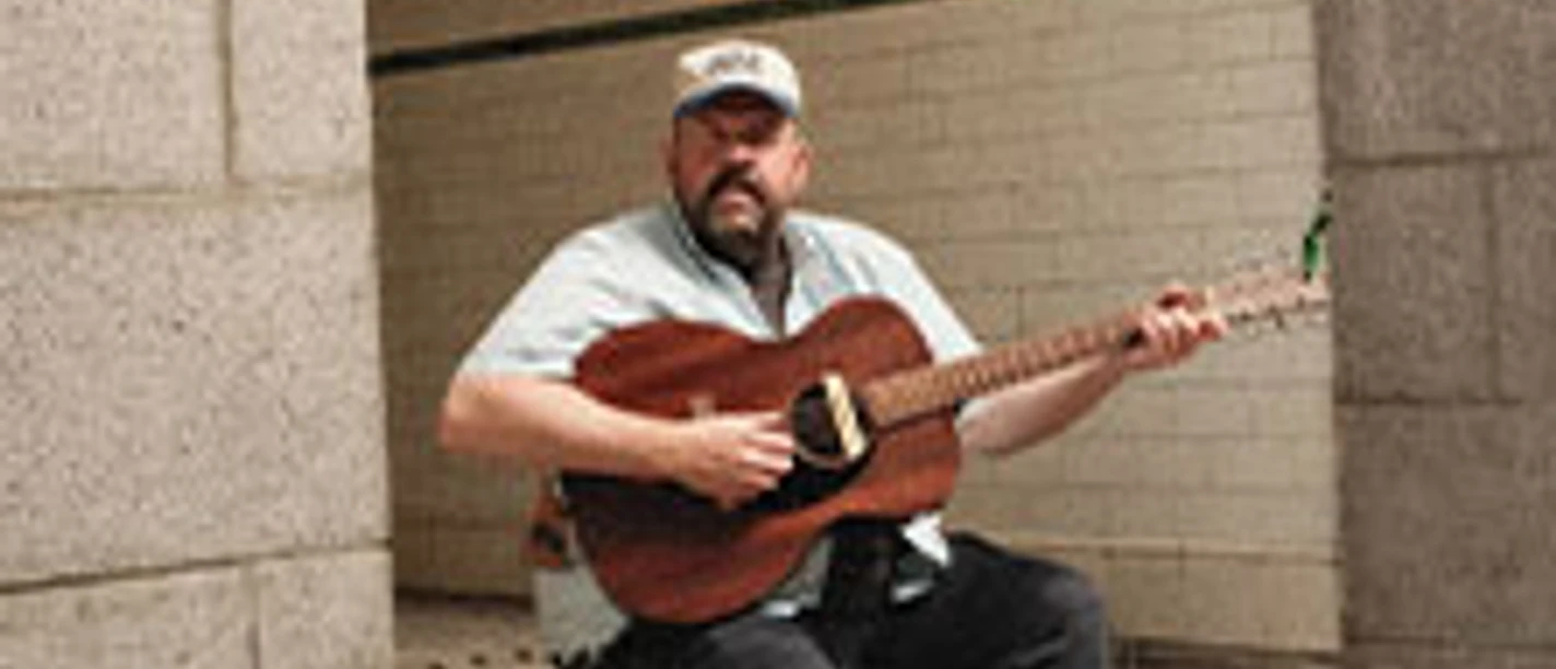 Tourplakat von Donovan Woods: Musiker mit Gitarre vor Betonwand, Europa-Tour