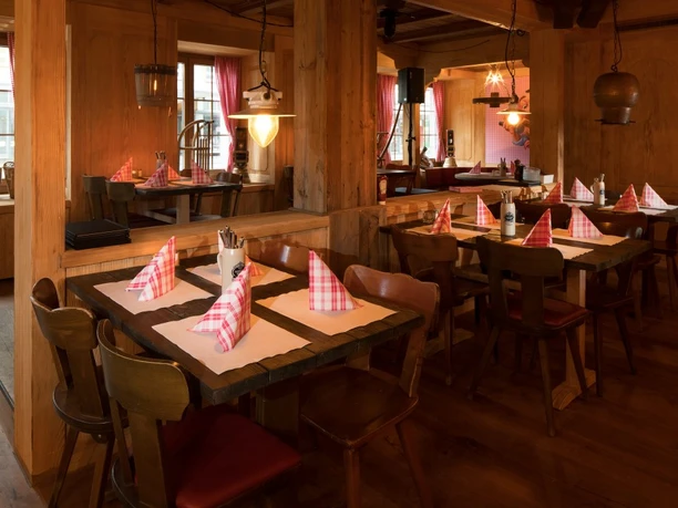 Wood-panelled restaurant interior with set tables and red checked napkins