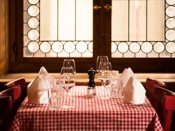 Set table with red checked cloth, folded napkins and glasses in a wood-panelled restaurant