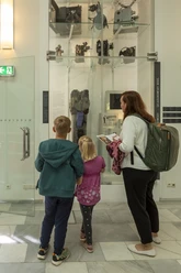 Familie auf Spurensuche bei der Potsdam-Filmrallye vor historischen Filmkameras im Museum.