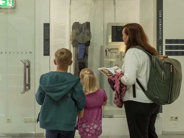 Familie auf Spurensuche bei der Potsdam-Filmrallye vor historischen Filmkameras im Museum.