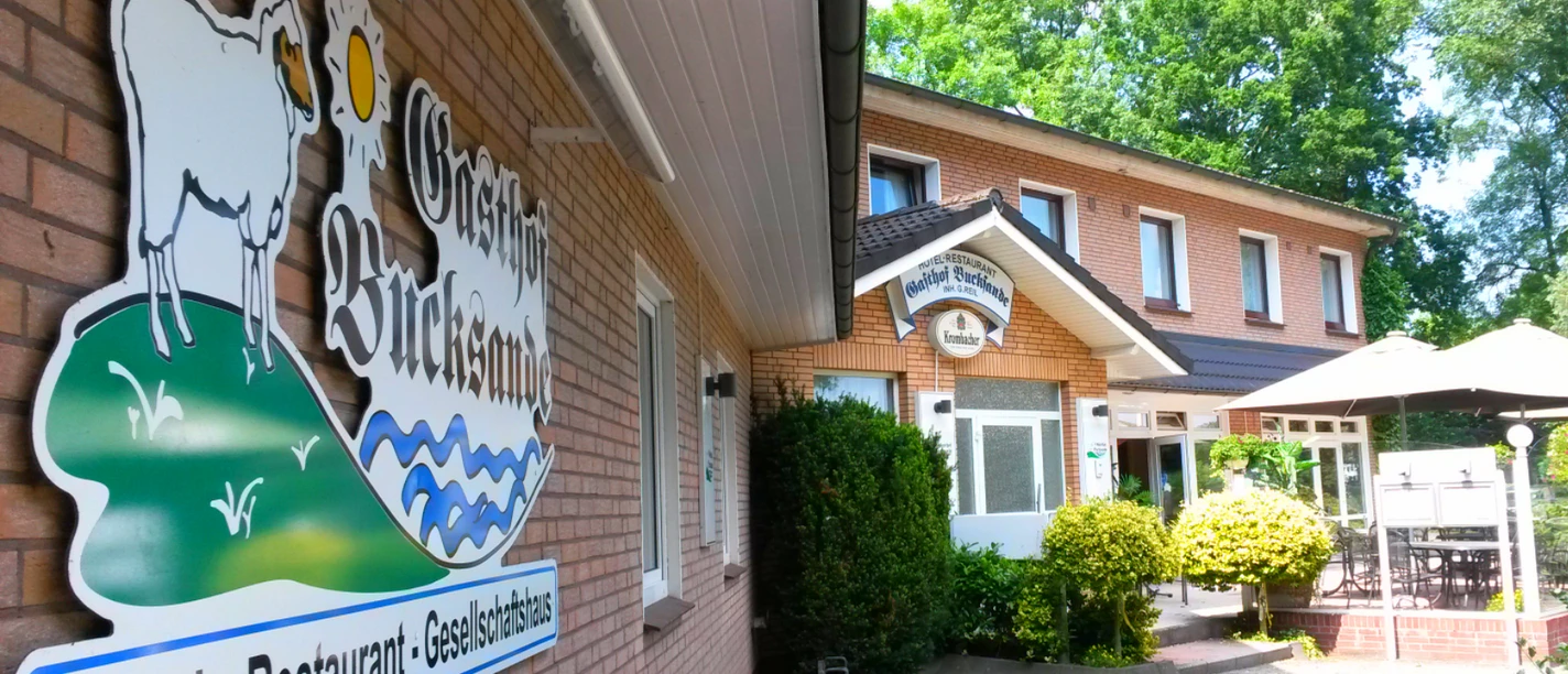 Aussenansicht Gasthof Bucksande. Vorne ist ein Schild mit dem Namen des Hotels zu sehen.